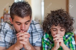 19637752-Two-Hispanic-brothers-praying-and-having-their-daily-Christian-devotional-at-home-Young-children-rel-Stock-Photo